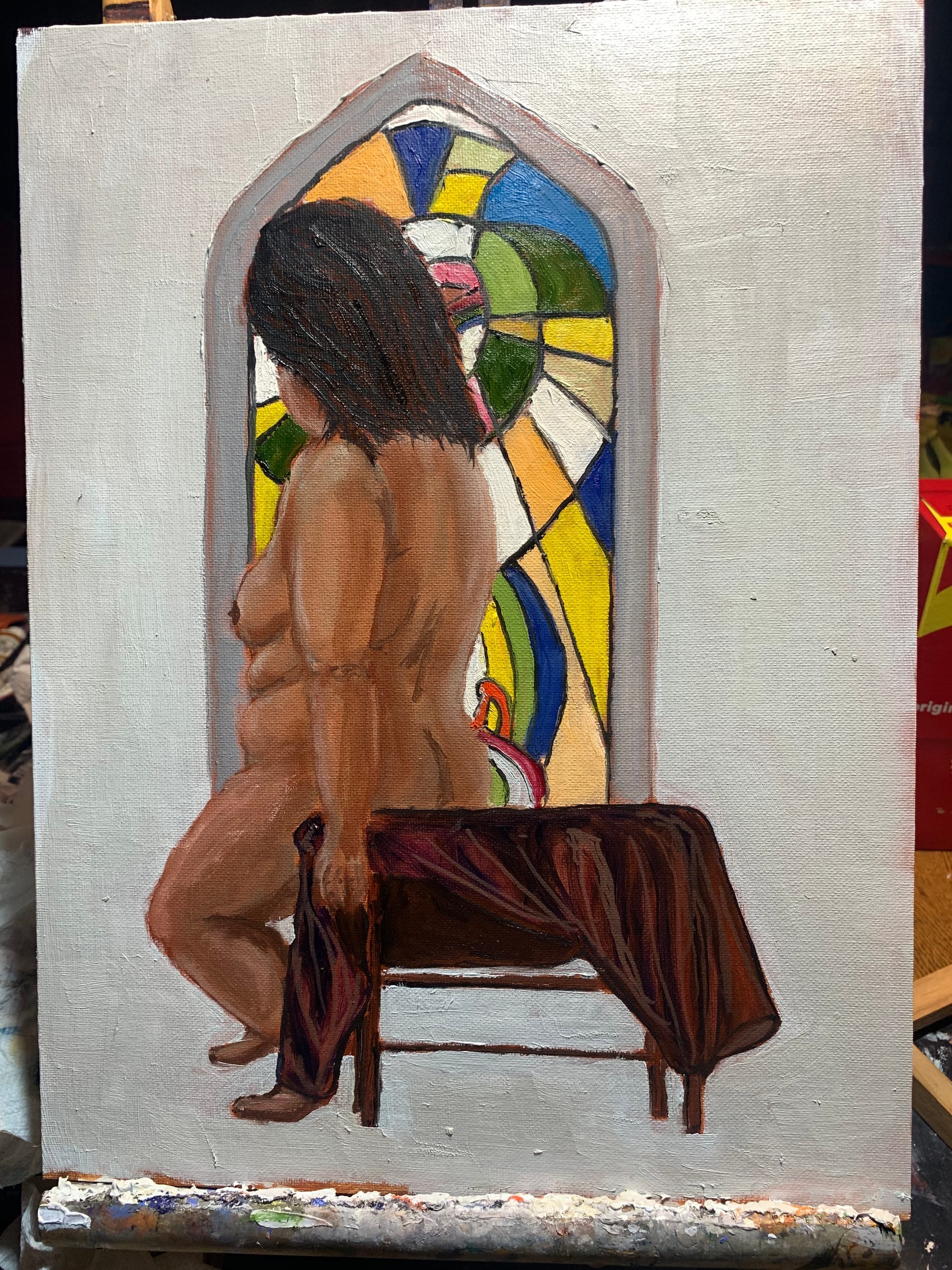 Painting of a seated nude figure beside a brightly coloured stained-glass window.
