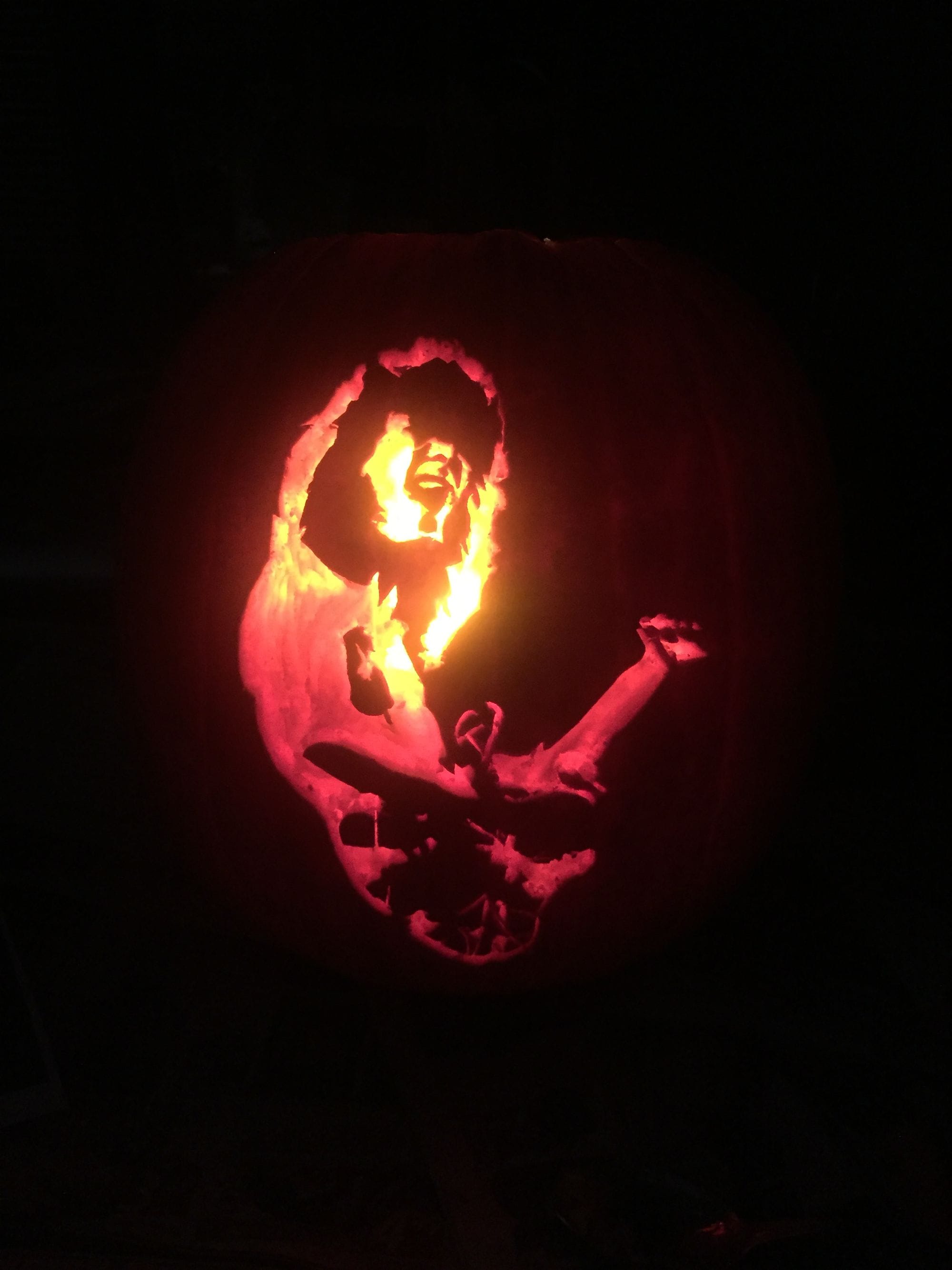 Illuminated pumpkin carving depicting a long-haired guitarist.