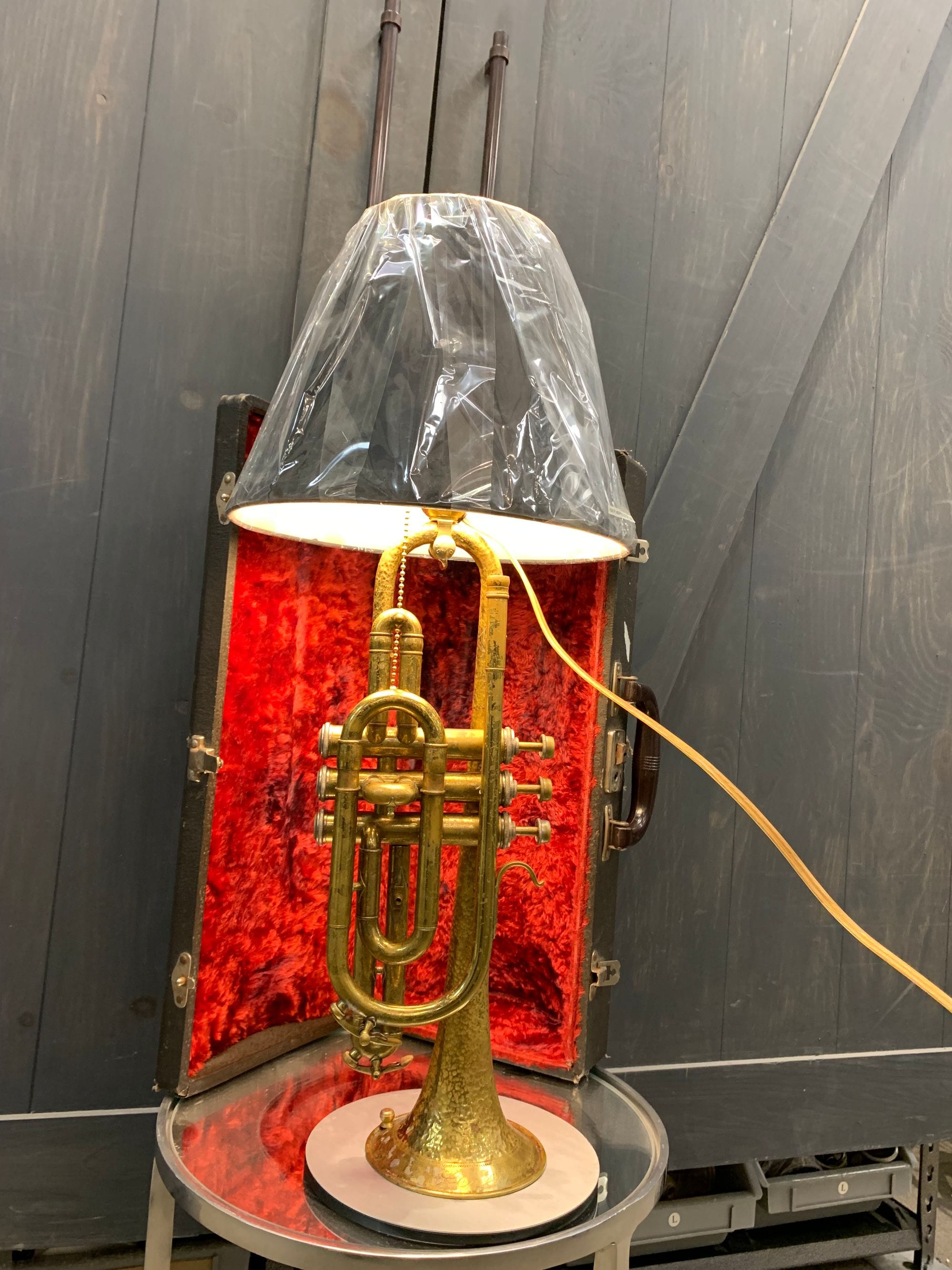 Table lamp made with a trumpet, displayed in its open instrument case.