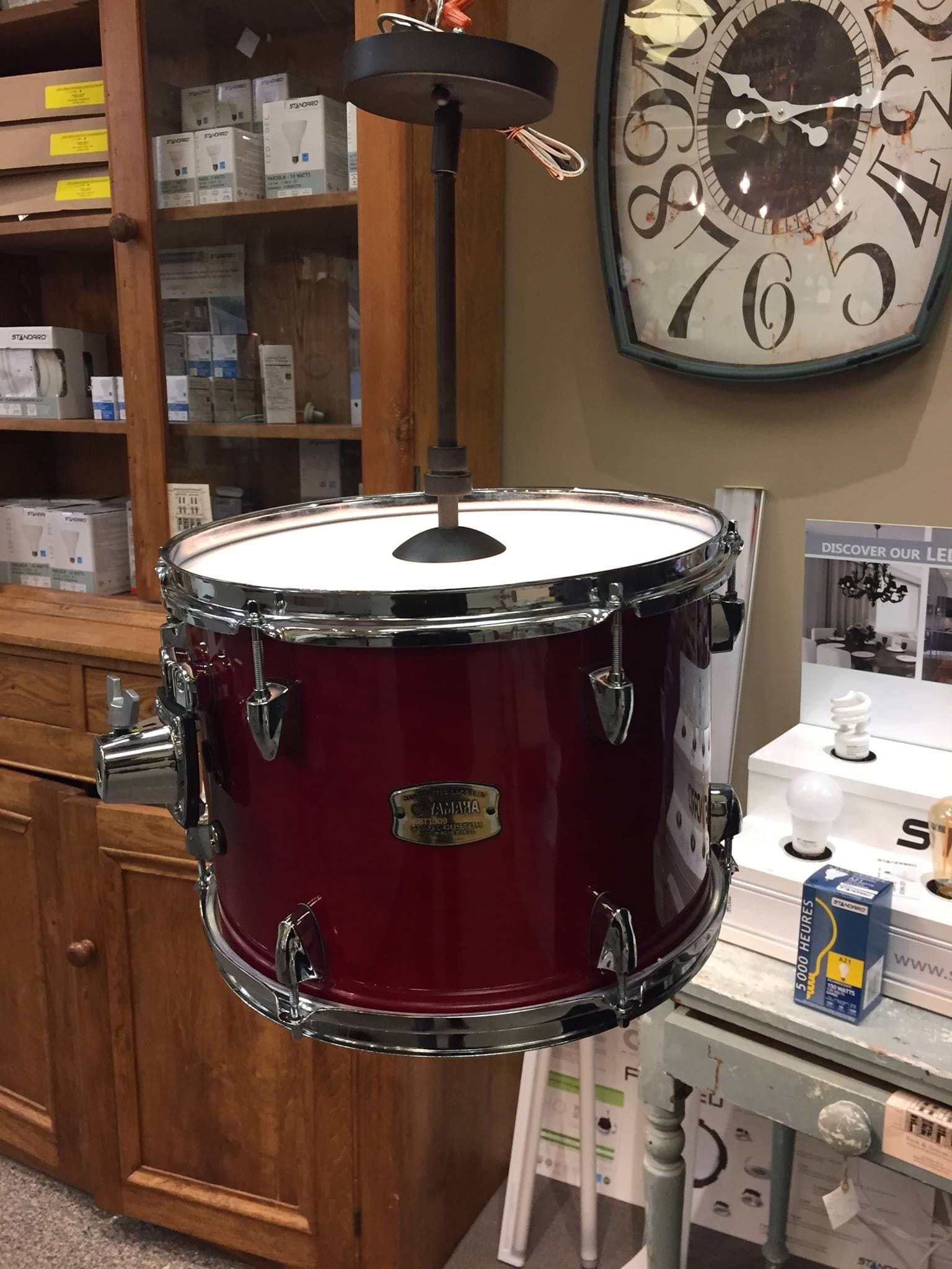 Lamp assembled with a red drum and a slim upright light fitting.