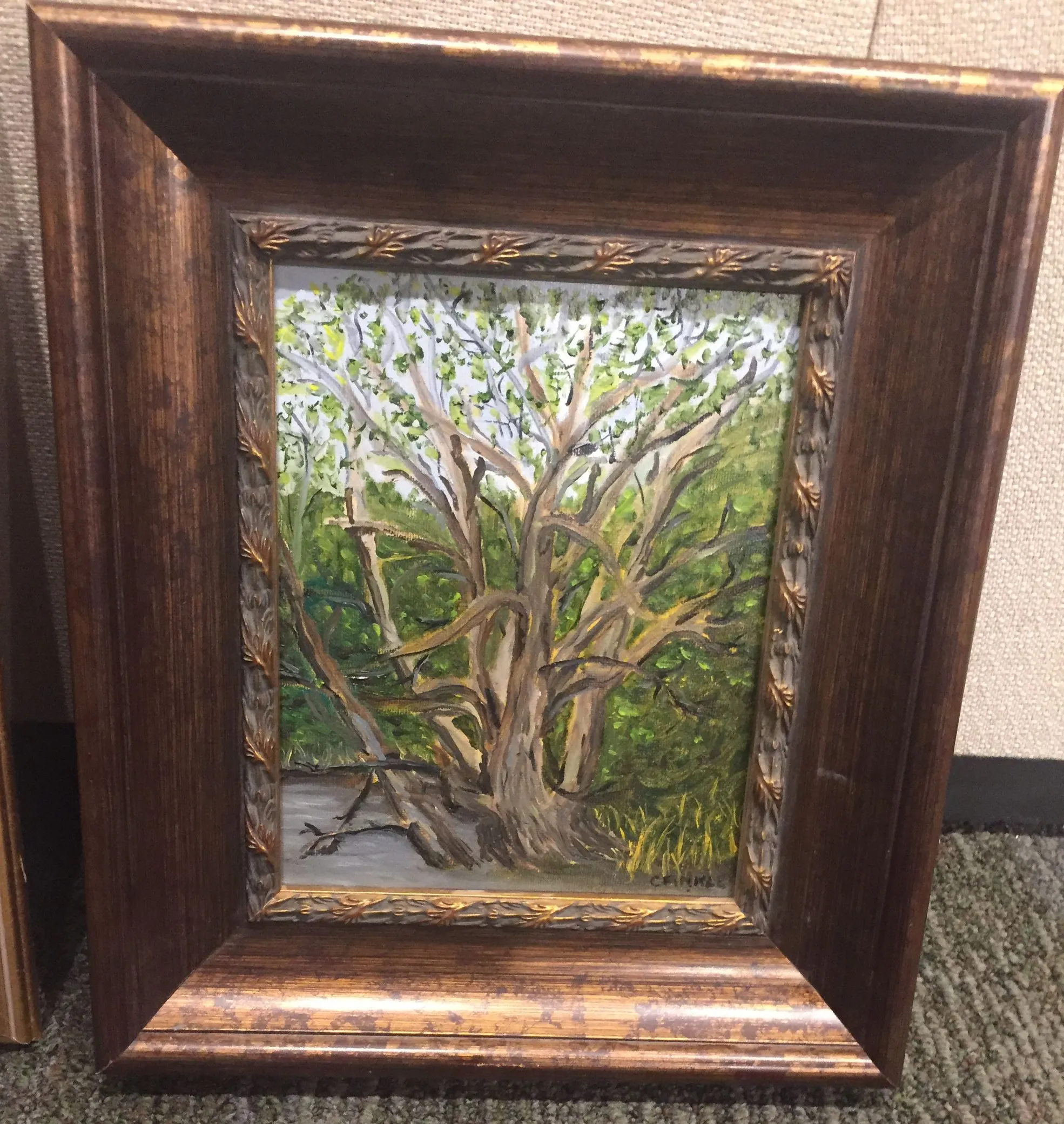 Framed painting of a tree with spreading branches and green foliage.