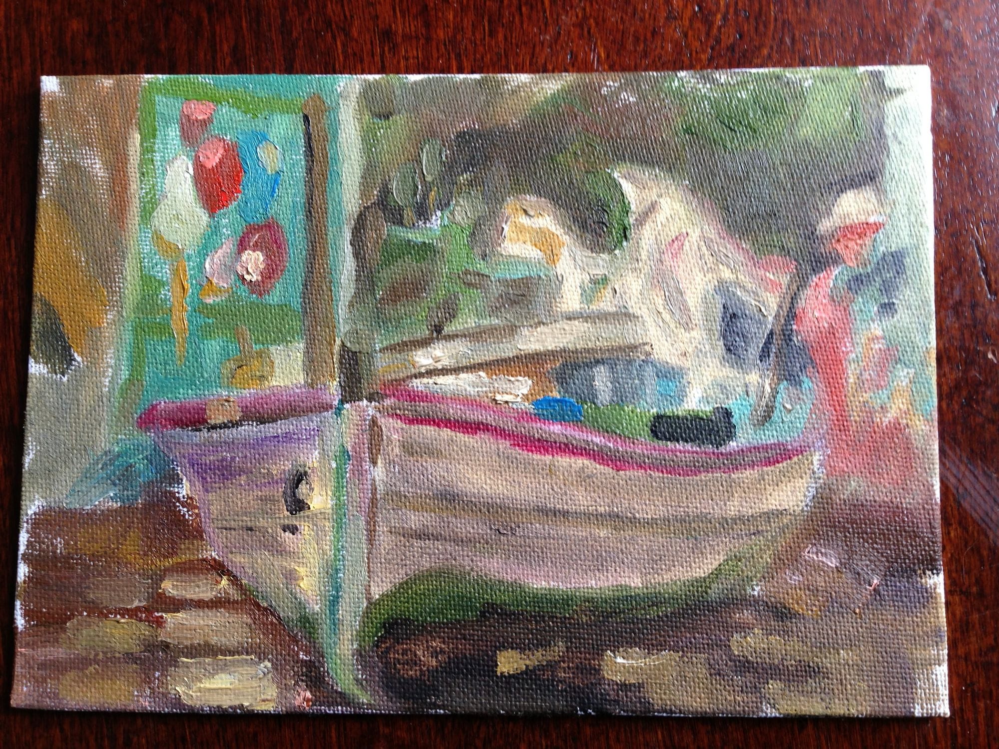 Small painting of a colourful boat resting on dry ground.