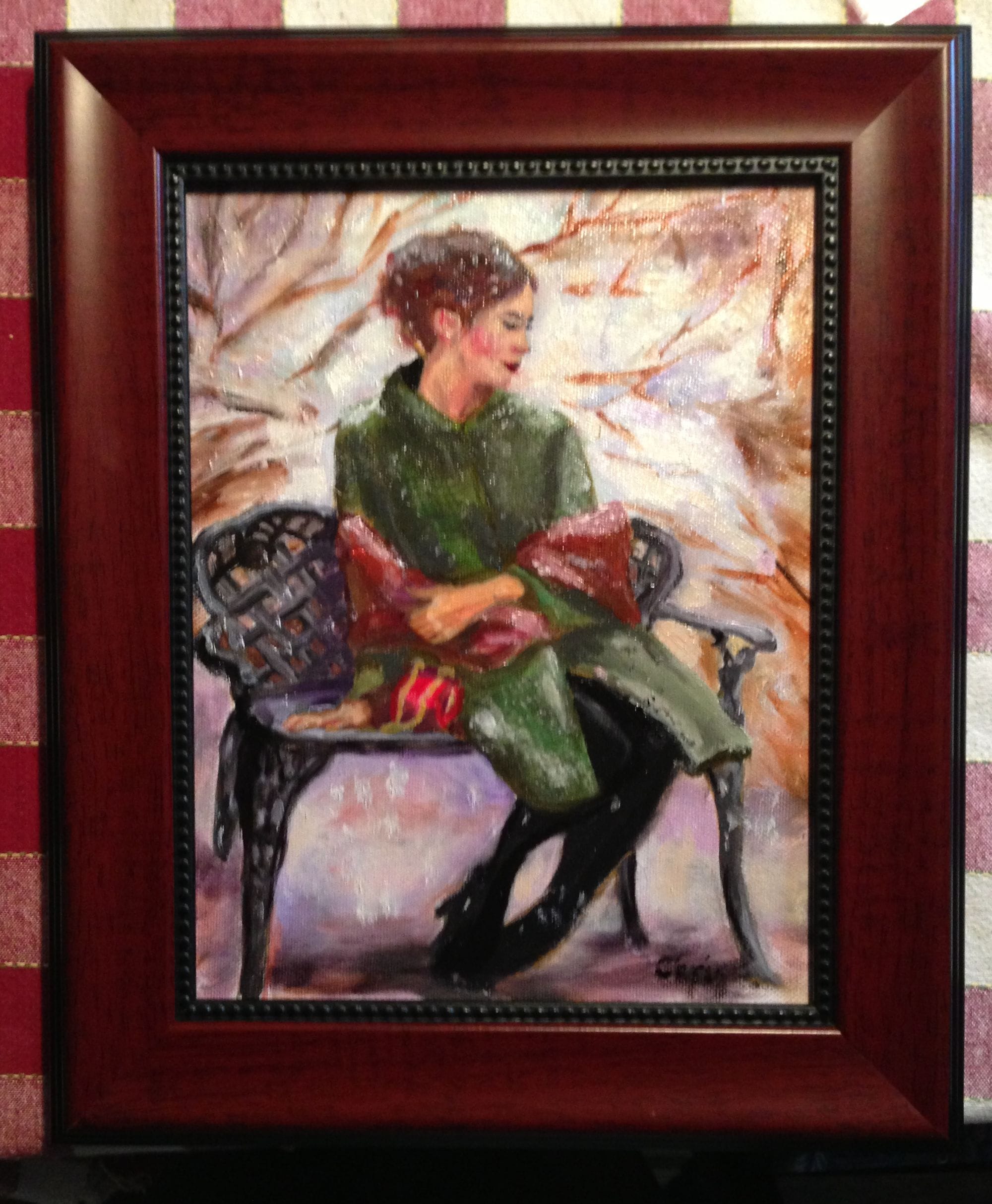 Framed portrait study of a woman in a green dress seated in a pale upholstered chair.