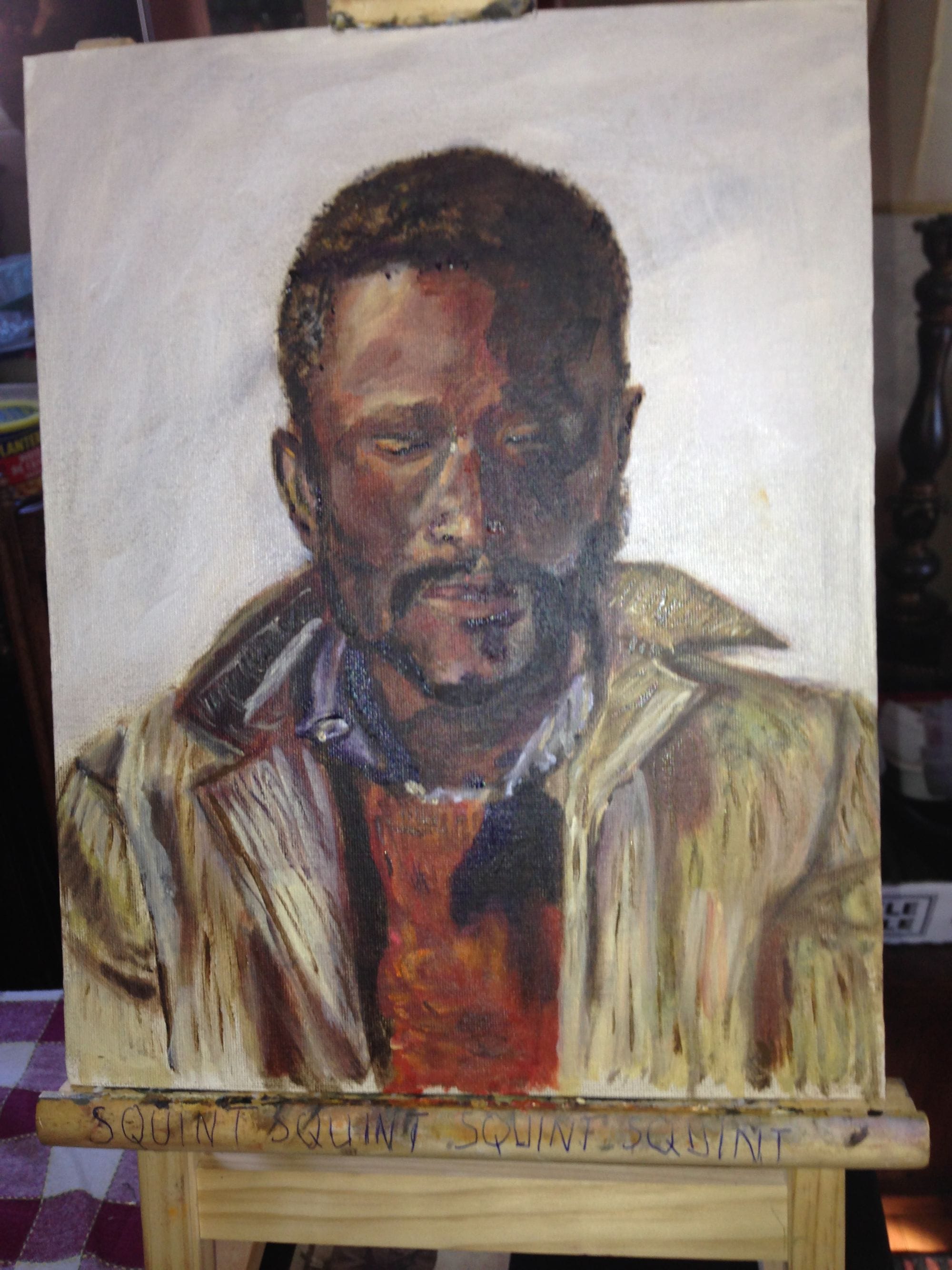 Portrait study of a man wearing a light jacket over a red shirt.